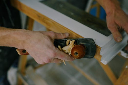 pexels-photo-5691541-5691541 Skilled carpenter smoothing wood surface with a hand plane for fine finish.